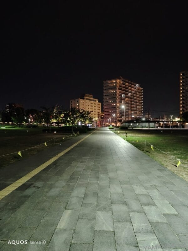 AQUOS sense10 カメラ 夜の公園にある舗装された歩道の風景